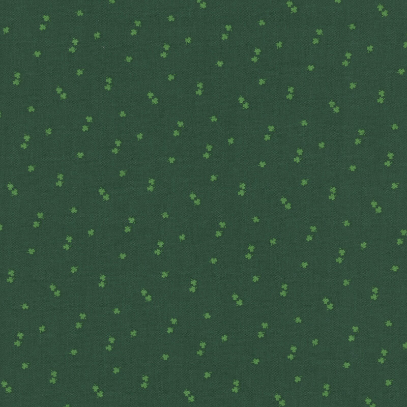 light green shamrocks tossed on a dark green fabric