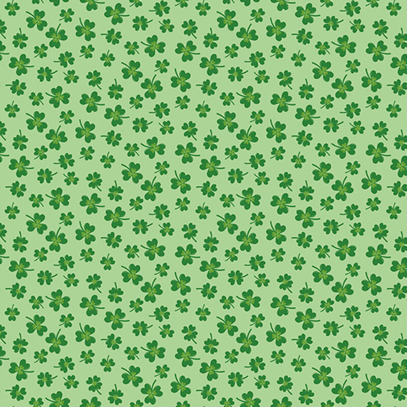 green clovers in various sizes scattered on mint green fabric