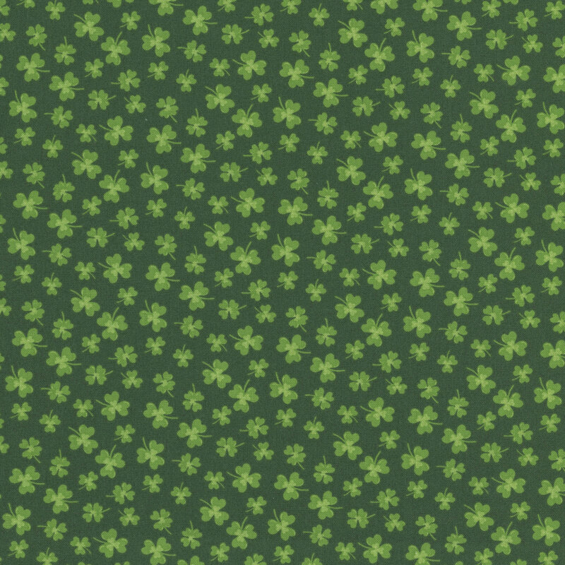 green clovers in various sizes scattered on dark green fabric