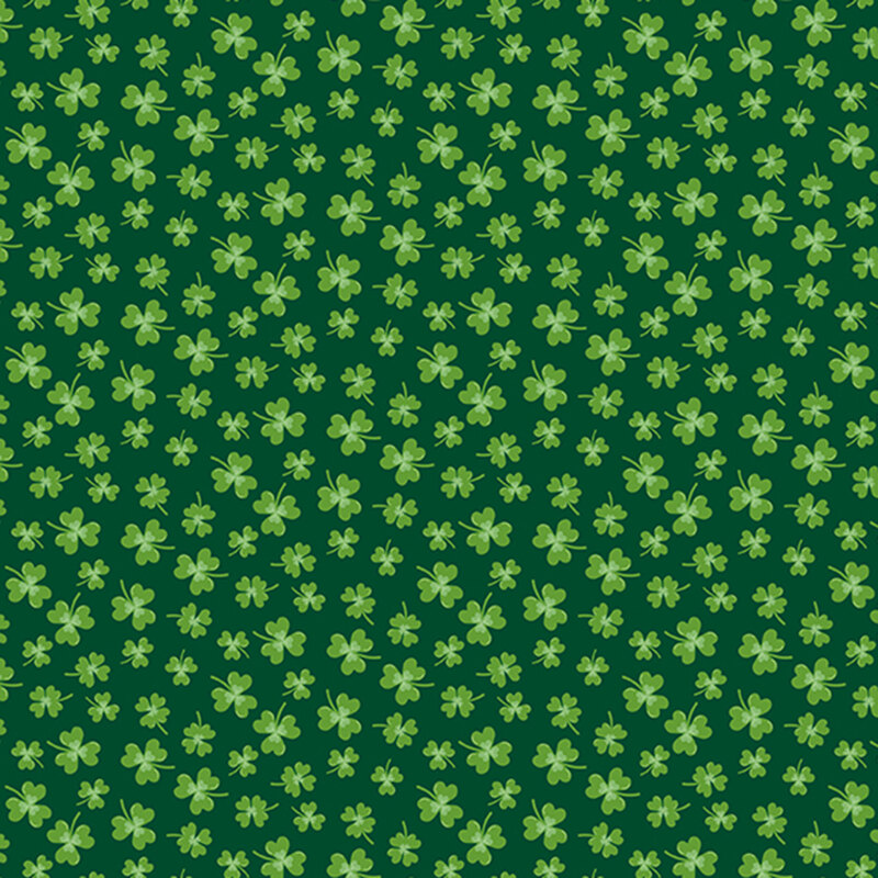 green clovers in various sizes scattered on dark green fabric