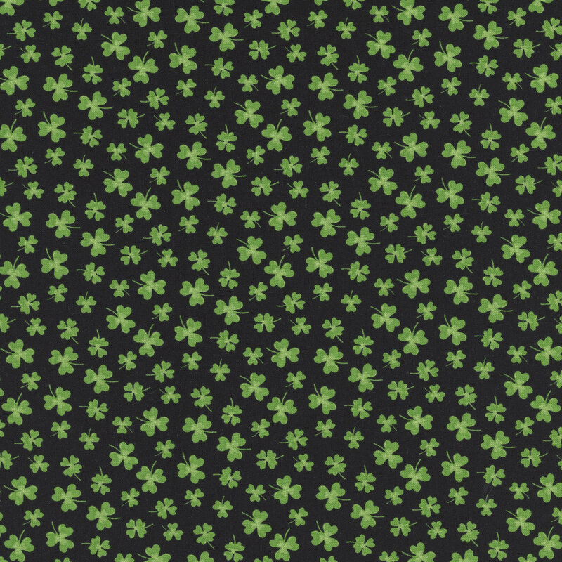green clovers in various sizes scattered on jet black fabric