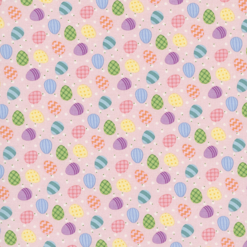 colorful easter eggs and white daisies scattered on pastel pink fabric