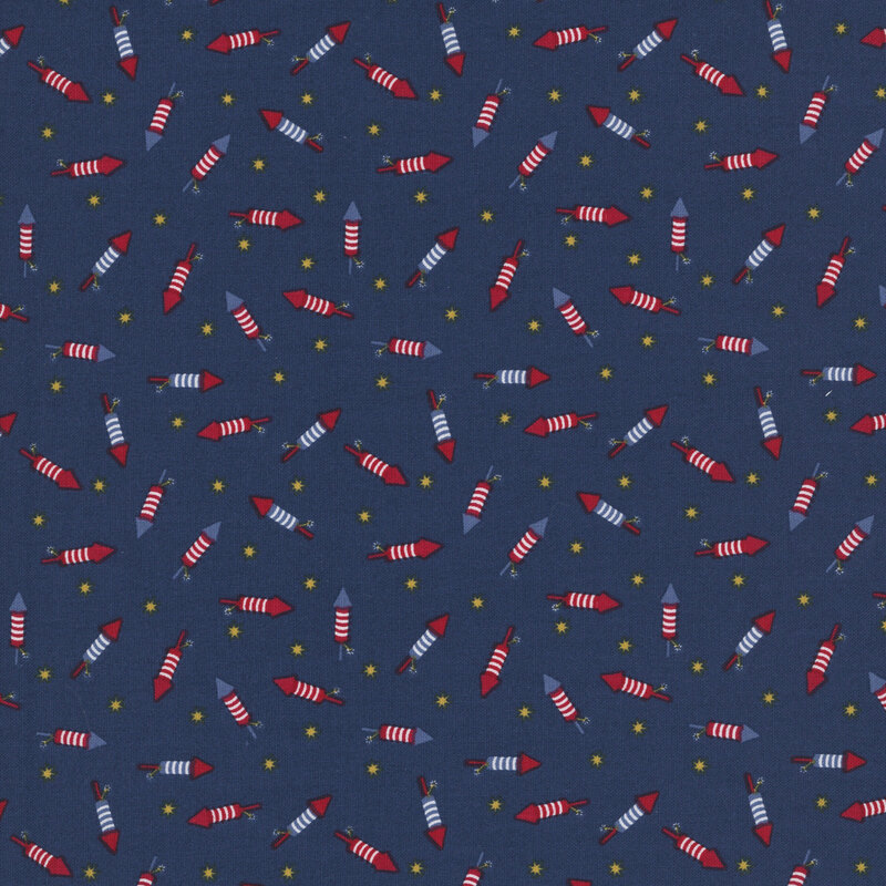 navy blue fabric tossed with bottle rockets in red, white and blue amongst yellow stars