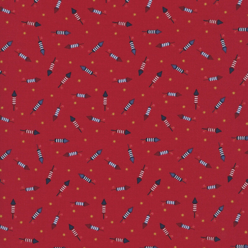 cherry red fabric tossed with bottle rockets in red, white and blue amongst yellow stars