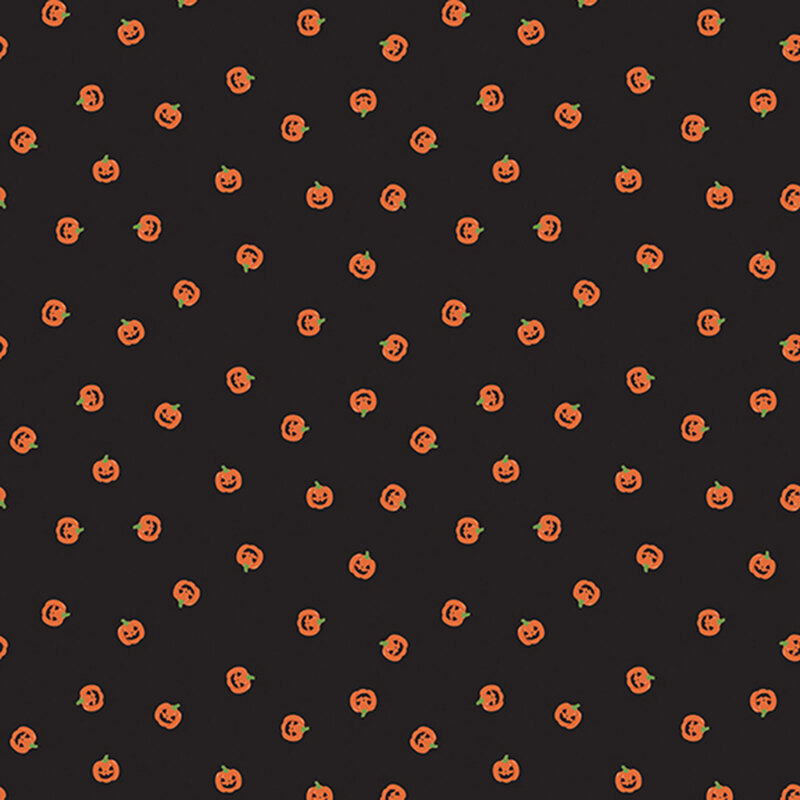 orange carved pumpkin heads scattered on black fabric