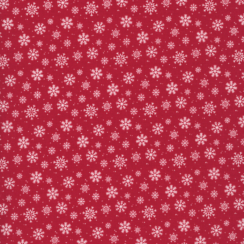 white snowflakes in various sizes scattered on cherry red fabric