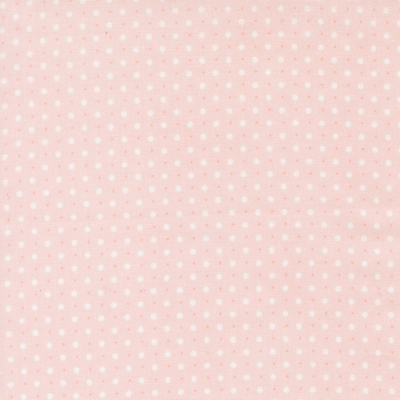 pink fabric with a pattern of small and tiny white polka dots.