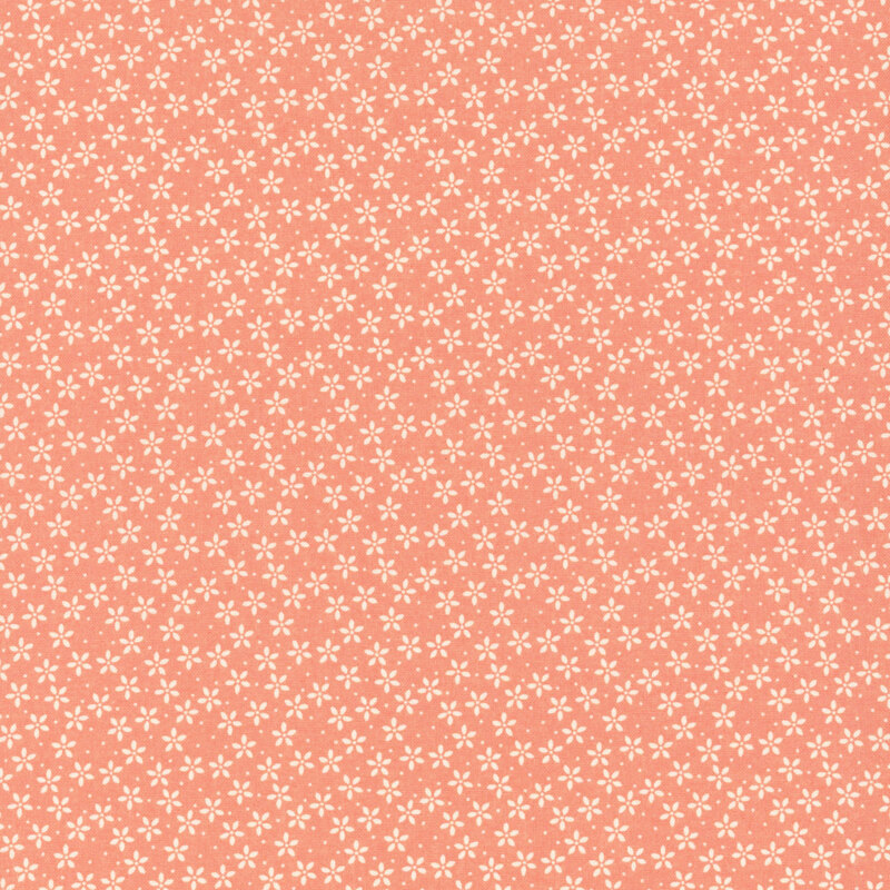 Bright coral fabric with tiny white flowers crowded together amongst pinprick dots.
