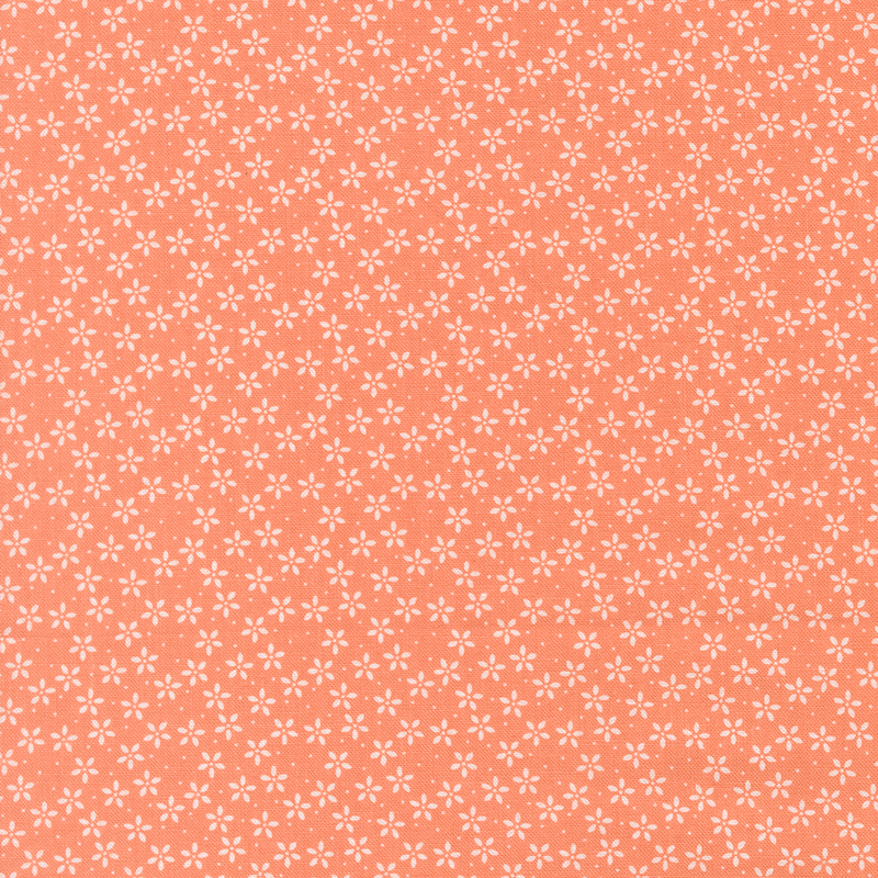 Bright coral fabric with tiny white flowers crowded together amongst pinprick dots.