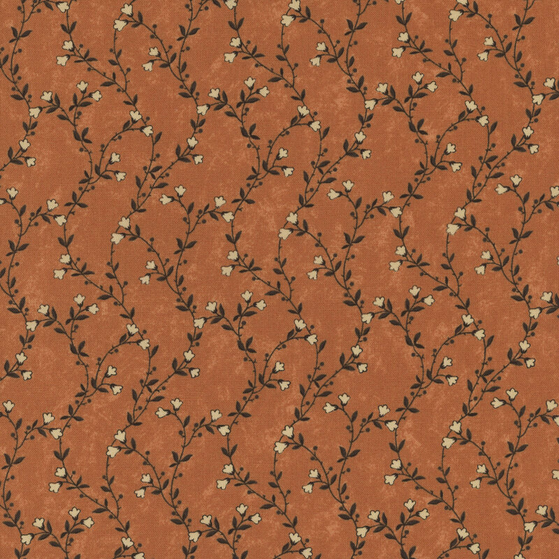 A mottled pumpkin orange fabric featuring delicate green vines with cream flowers. 