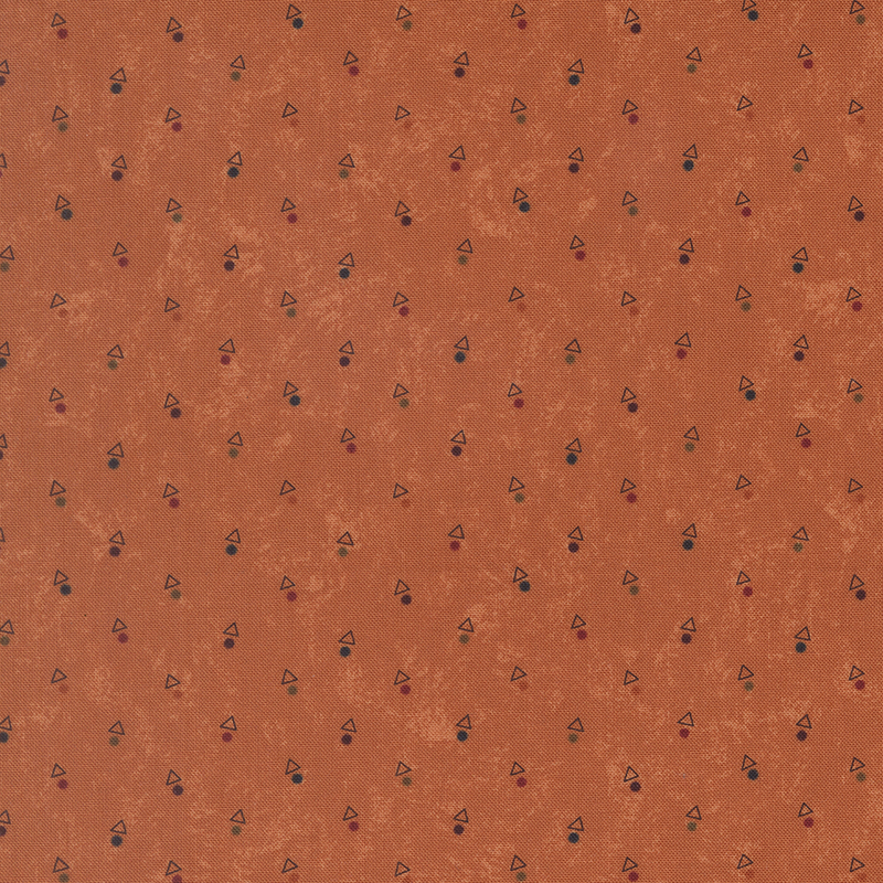 A mottled pumpkin orange fabric with triangles and multicolored dots. 