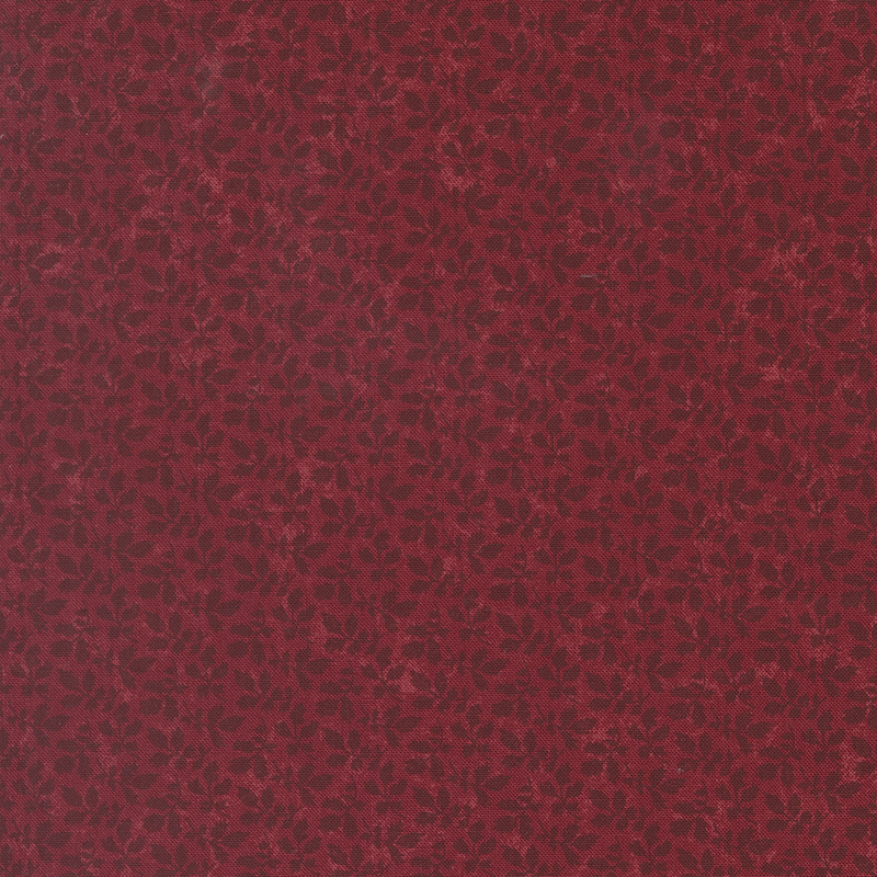 A mottled brick red fabric with tonal leaf clusters. 