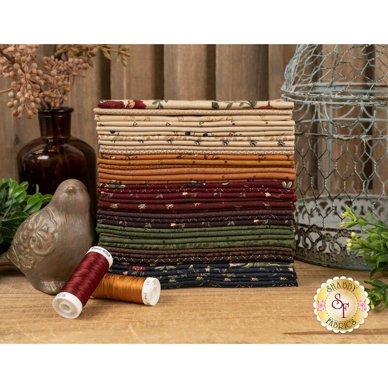 A stack of fabrics featured in the Quail Run F8 set, with a bird and a birdcage and plants and a vase and thread.