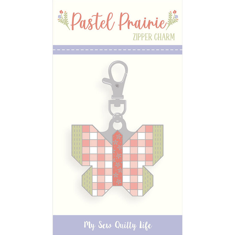 An enamel and metal zipper pull in its packaging in the shape of a butterfly.