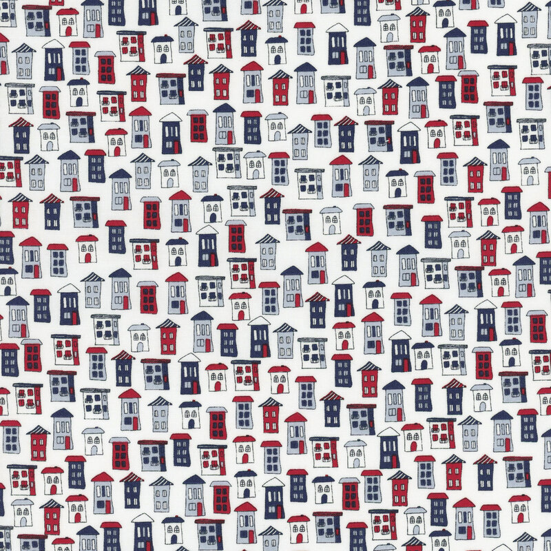cloud white fabric featuring whimsical hand-drawn houses in different color mixes of red, cornflower blue, and navy blue.