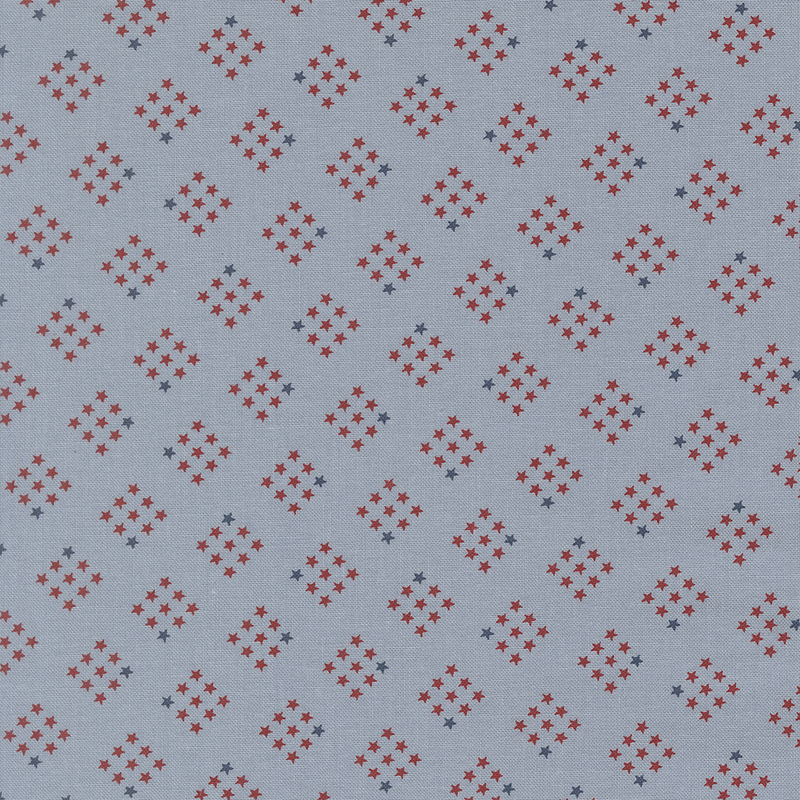 cornflower blue fabric featuring diamond-shaped clusters of red and navy stars