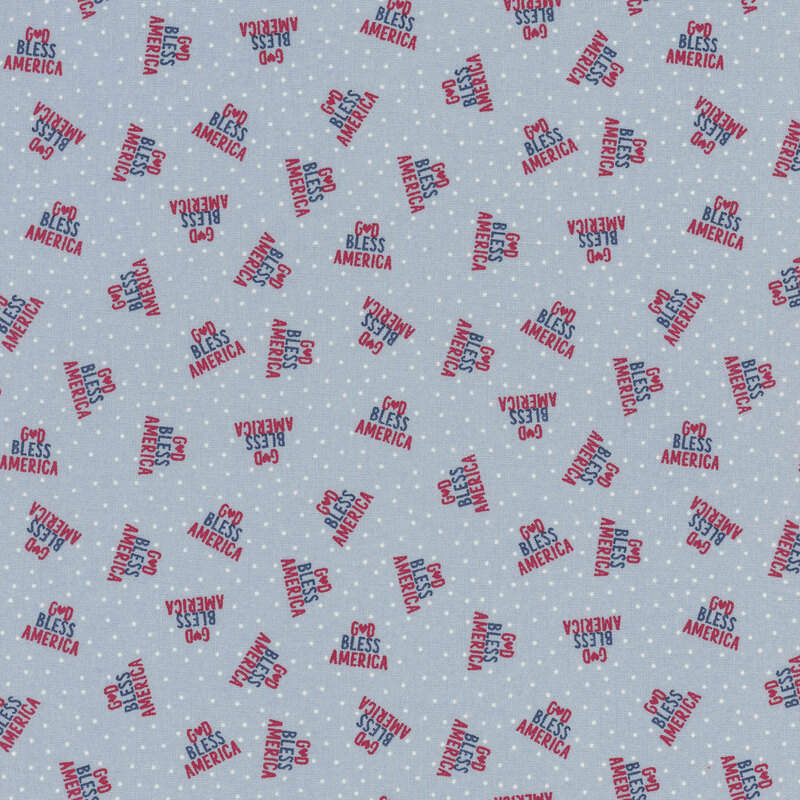 faded denim blue fabric featuring God Bless America in a triangle of red and navy text on a background of white polka dots