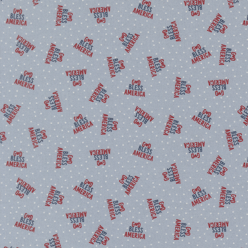 faded denim blue fabric featuring God Bless America in a triangle of red and navy text on a background of white polka dots
