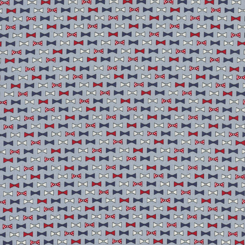 rows of bowties in red, light gray, navy blue, and red with white polka dots on cornflower blue fabric