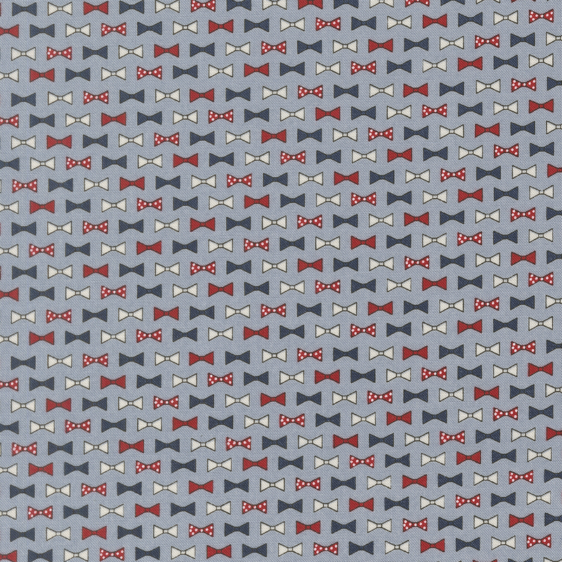 rows of bowties in red, light gray, navy blue, and red with white polka dots on cornflower blue fabric