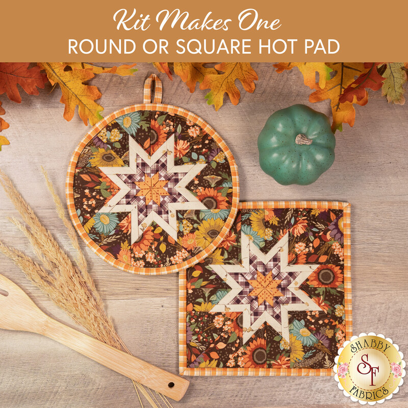 The two completed brown Folded Star Hot Pads, one round and one square, slightly overlapping each other and staged on a wooden table with coordinating autumnal-themed décor and cooking ware.