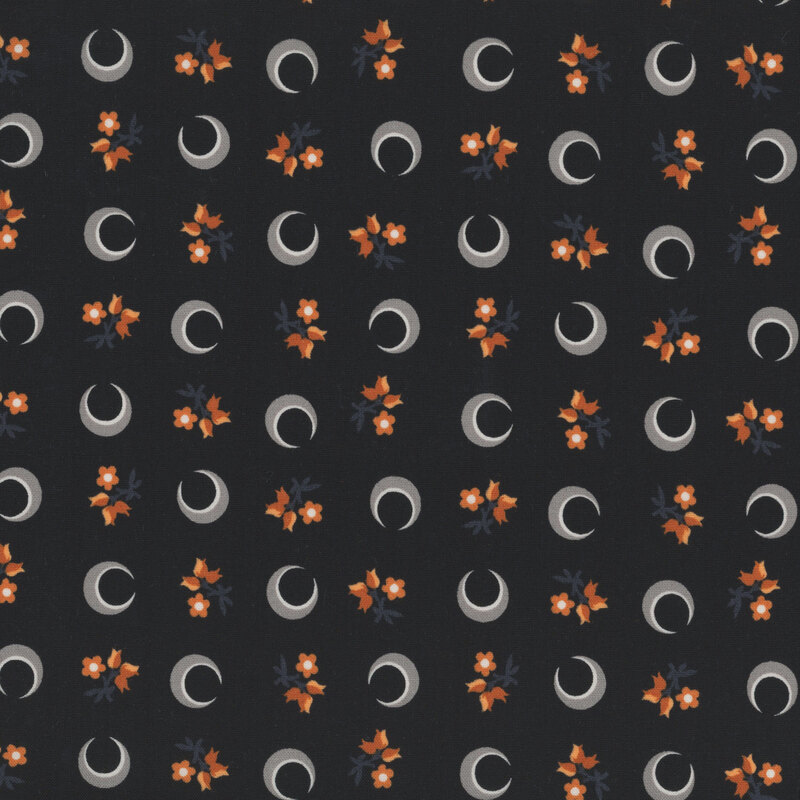 Black fabric with a tossed pattern of crescent moons and florals.