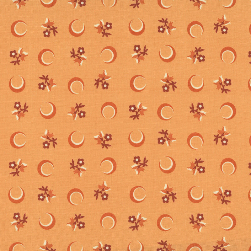 Orange fabric with a tossed pattern of crescent moons and florals.