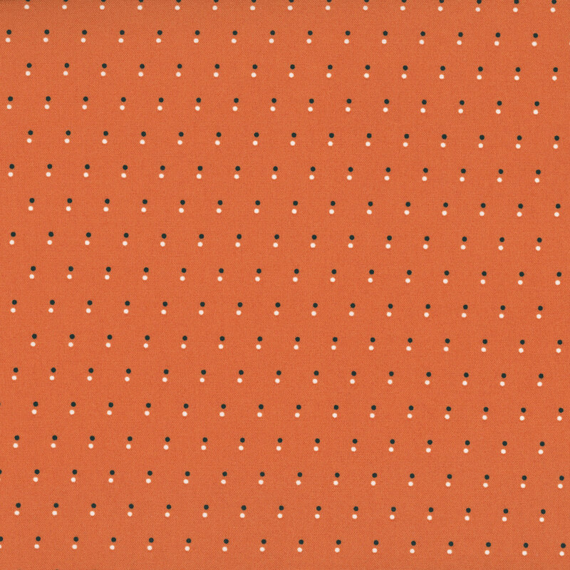Orange fabric with a pattern of evenly spaced dots in black and white.