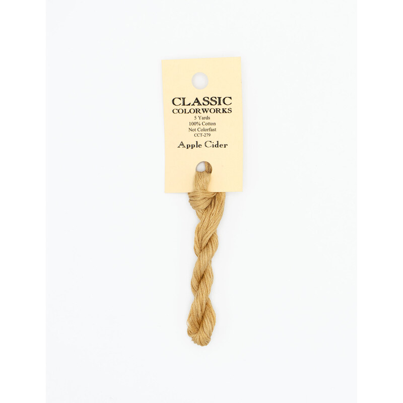 A skein of tan embroidery floss, twisted and bundled, with a cream and black label featuring the brand name and color information.