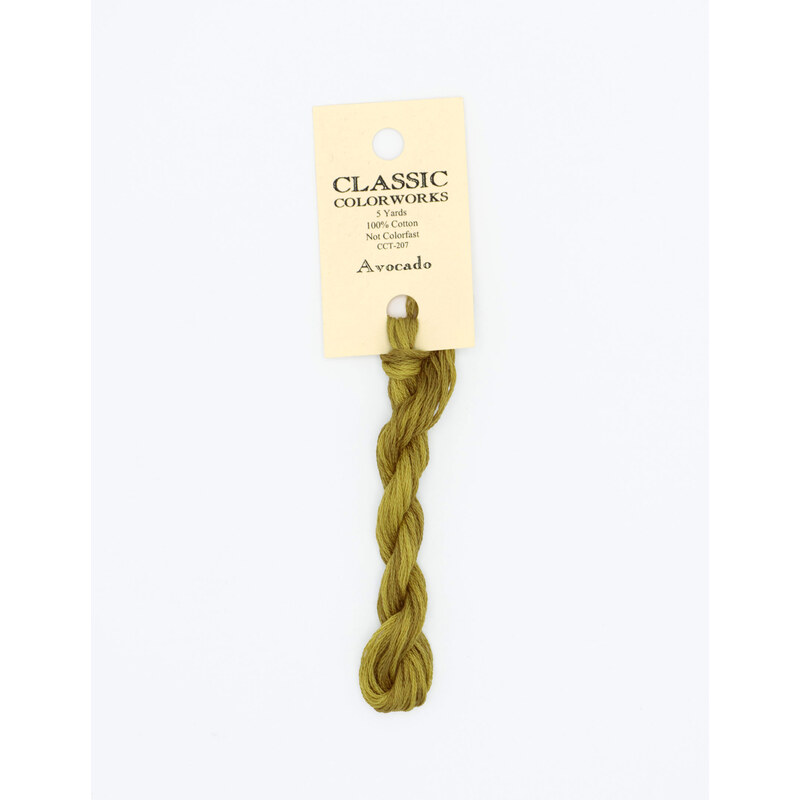 A skein of muted green embroidery floss, twisted and bundled, with a cream and black label featuring the brand name and color information.