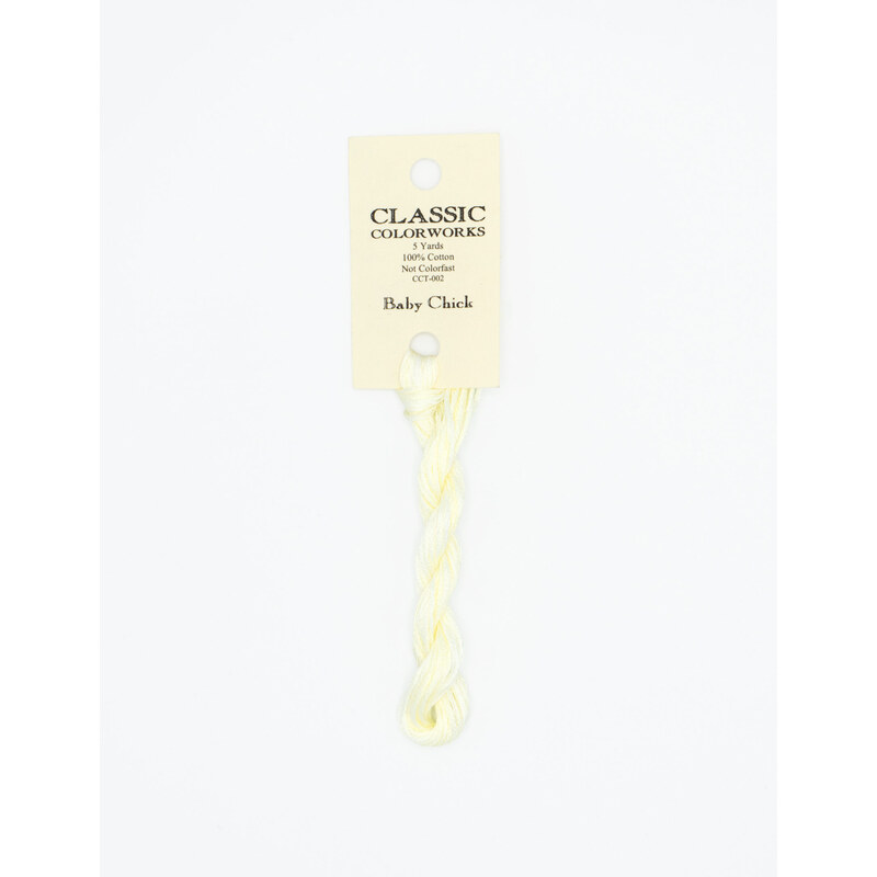 A skein of light yellow embroidery floss, twisted and bundled, with a cream and black label featuring the brand name and color information.