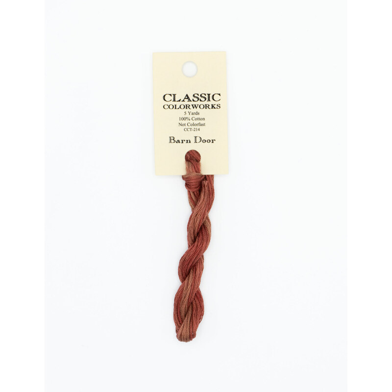 A skein of muted red embroidery floss, twisted and bundled, with a cream and black label featuring the brand name and color information.