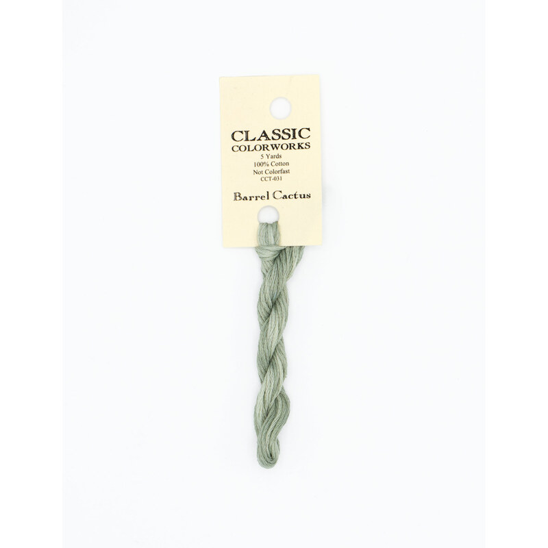 A skein of jade green embroidery floss, twisted and bundled, with a cream and black label featuring the brand name and color information.
