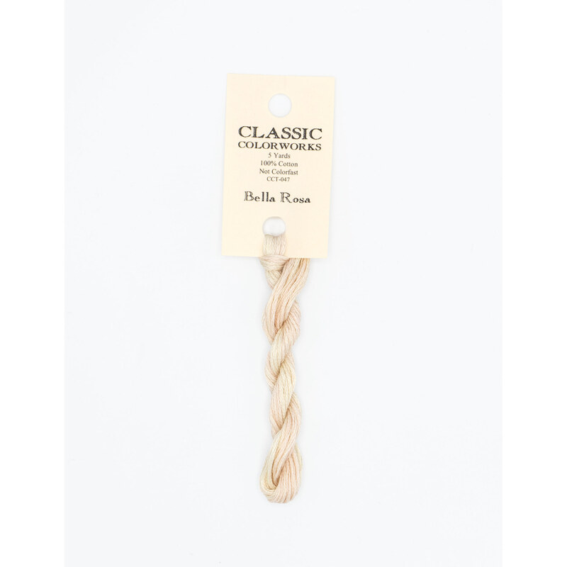 A skein of very light pink embroidery floss, twisted and bundled, with a cream and black label featuring the brand name and color information.