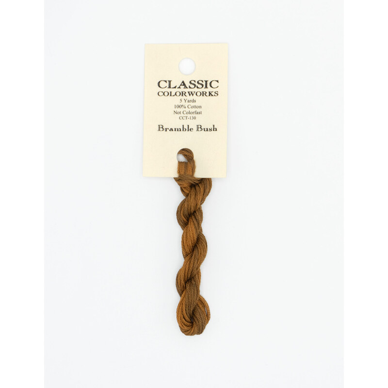 A skein of sienna brown embroidery floss, twisted and bundled, with a cream and black label featuring the brand name and color information.