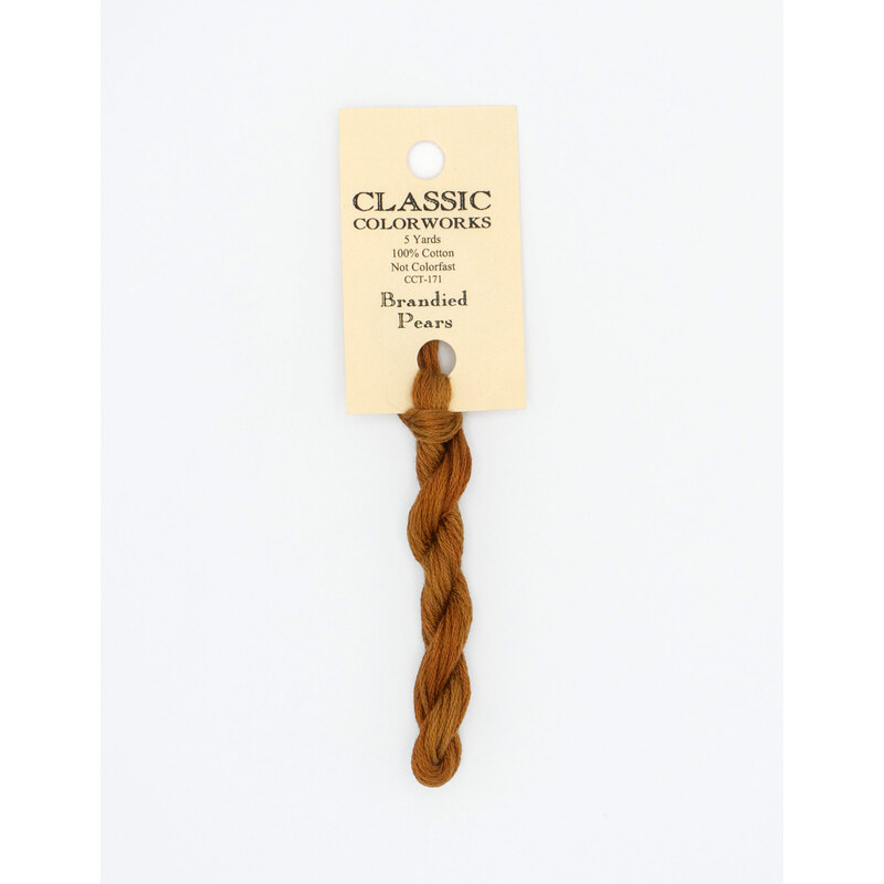 A skein of cinnamon brown embroidery floss, twisted and bundled, with a cream and black label featuring the brand name and color information.