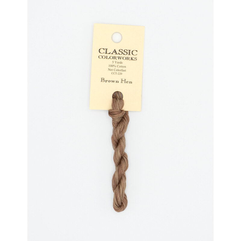 A skein of light brown embroidery floss, twisted and bundled, with a cream and black label featuring the brand name and color information.