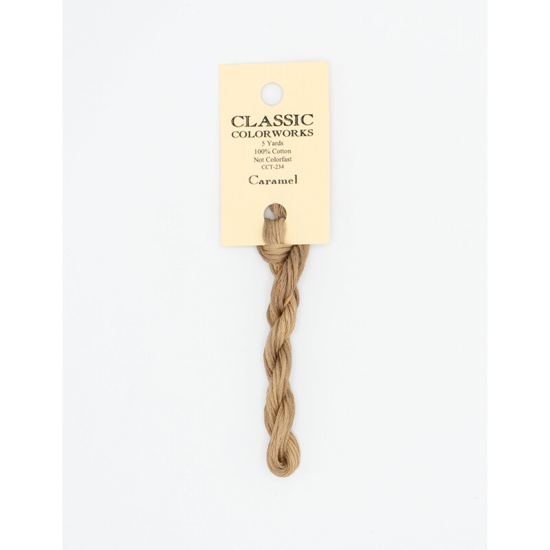 A skein of tan embroidery floss, twisted and bundled, with a cream and black label featuring the brand name and color information.