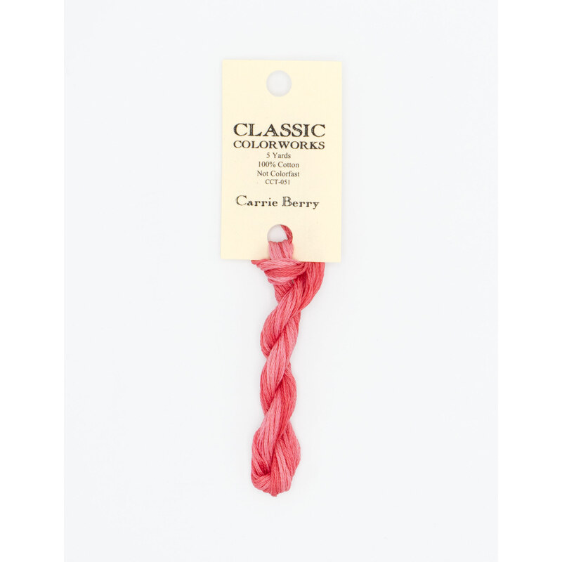 A skein of candy pink embroidery floss, twisted and bundled, with a cream and black label featuring the brand name and color information.