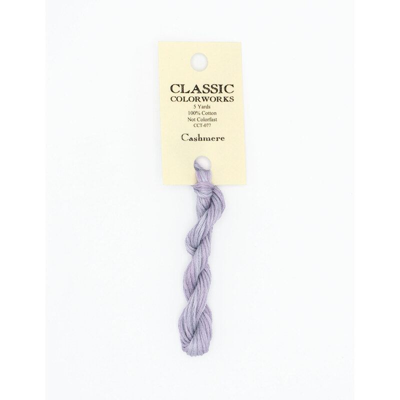 A skein of light periwinkle embroidery floss, twisted and bundled, with a cream and black label featuring the brand name and color information.