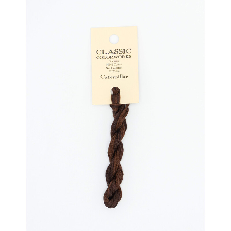 A skein of espresso brown embroidery floss, twisted and bundled, with a cream and black label featuring the brand name and color information.