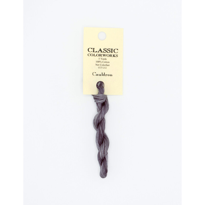 A skein of blue gray embroidery floss, twisted and bundled, with a cream and black label featuring the brand name and color information.