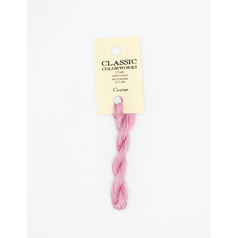 A skein of light pink embroidery floss, twisted and bundled, with a cream and black label featuring the brand name and color information.