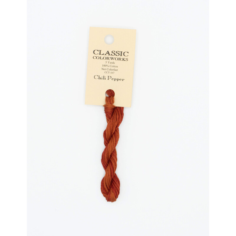 A skein of reddish orange embroidery floss, twisted and bundled, with a cream and black label featuring the brand name and color information.