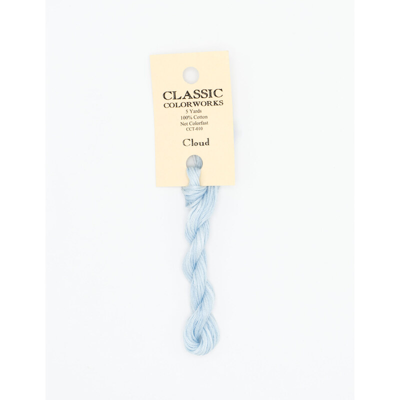 A skein of sky blue embroidery floss, twisted and bundled, with a cream and black label featuring the brand name and color information.