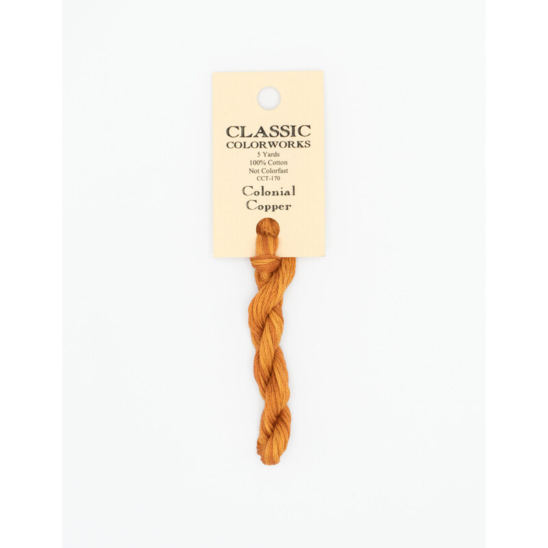 A skein of marigold orange embroidery floss, twisted and bundled, with a cream and black label featuring the brand name and color information.