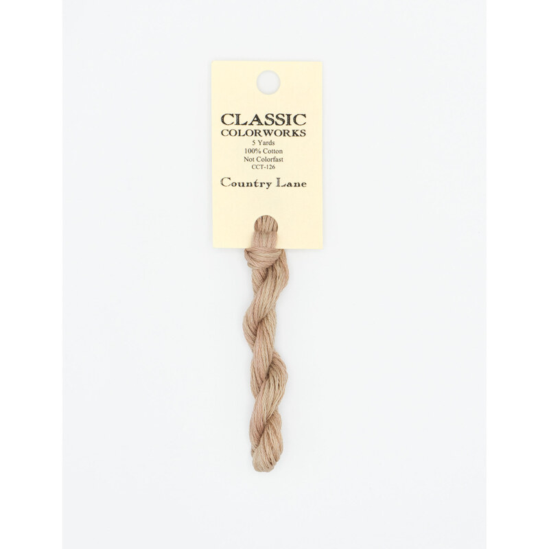 A skein of tan embroidery floss, twisted and bundled, with a cream and black label featuring the brand name and color information.