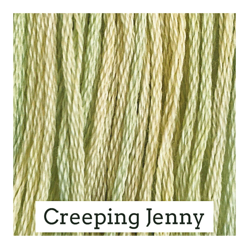 A variegated swatch of Classic Colorworks floss in the colors light yellow and light green. 