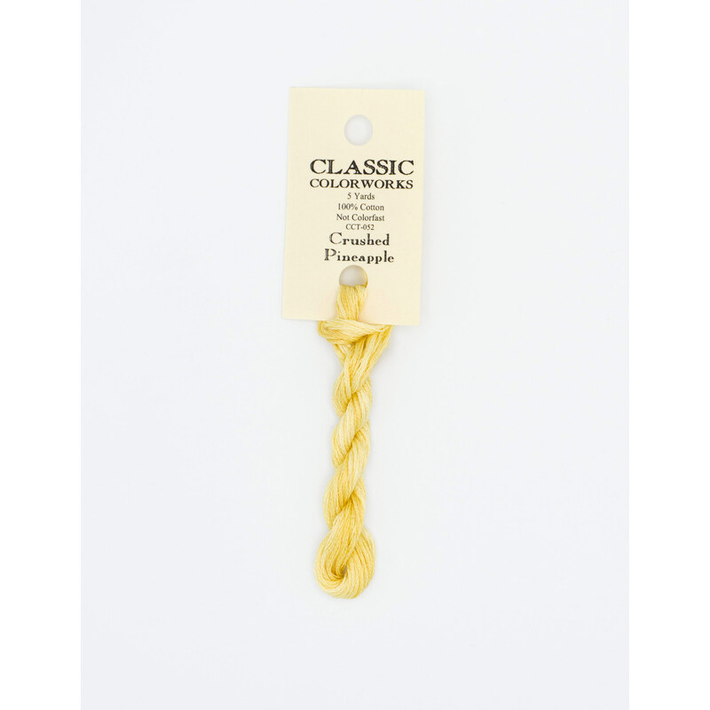 A skein of yellow embroidery floss, twisted and bundled, with a cream and black label featuring the brand name and color information.
