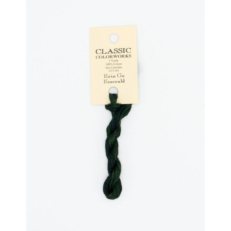A skein of emerald green embroidery floss, twisted and bundled, with a cream and black label featuring the brand name and color information.